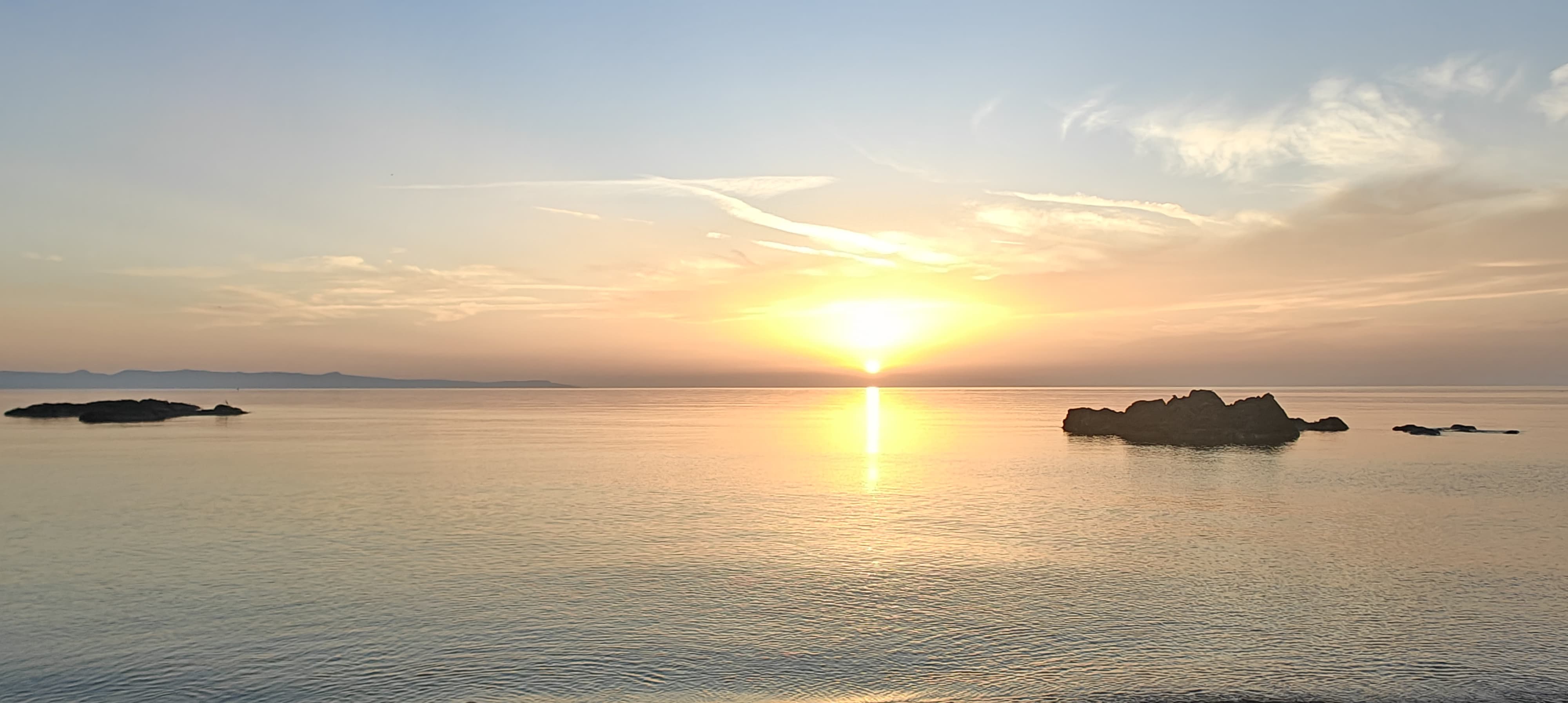 Sonnenuntergang über dem Meer bei Pomos, Zypern — die Sonne steht auf dem Horizont, eine goldene Lichtbahn läuft über das Wasser