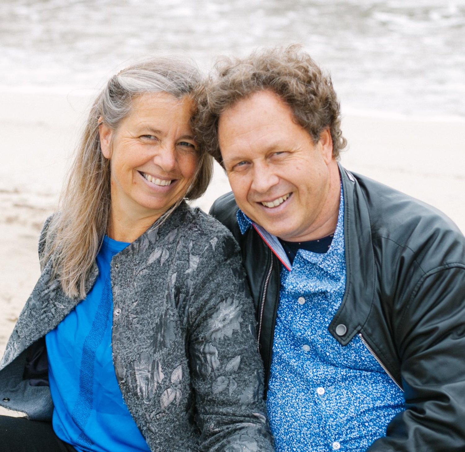 Annette und Herbert eng beieinander am Strand, beide lachen